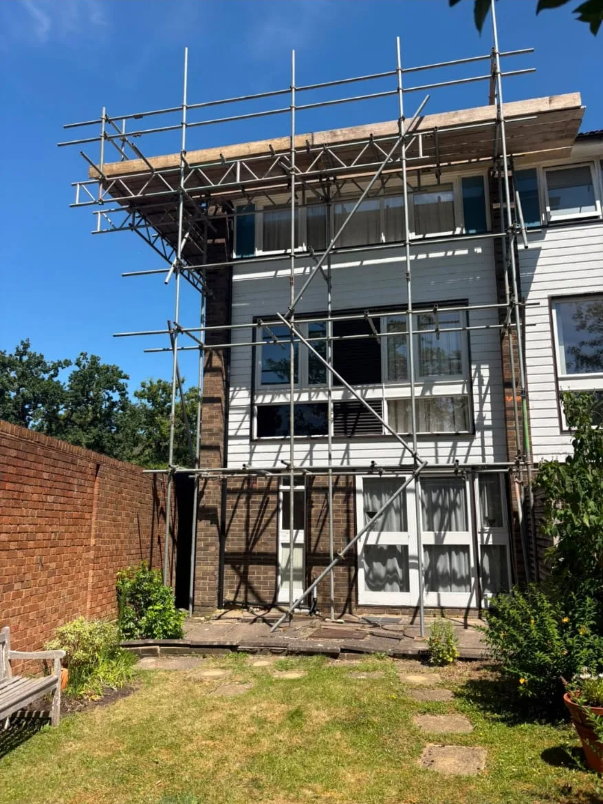 Scaffolding across the rear of a white clad house