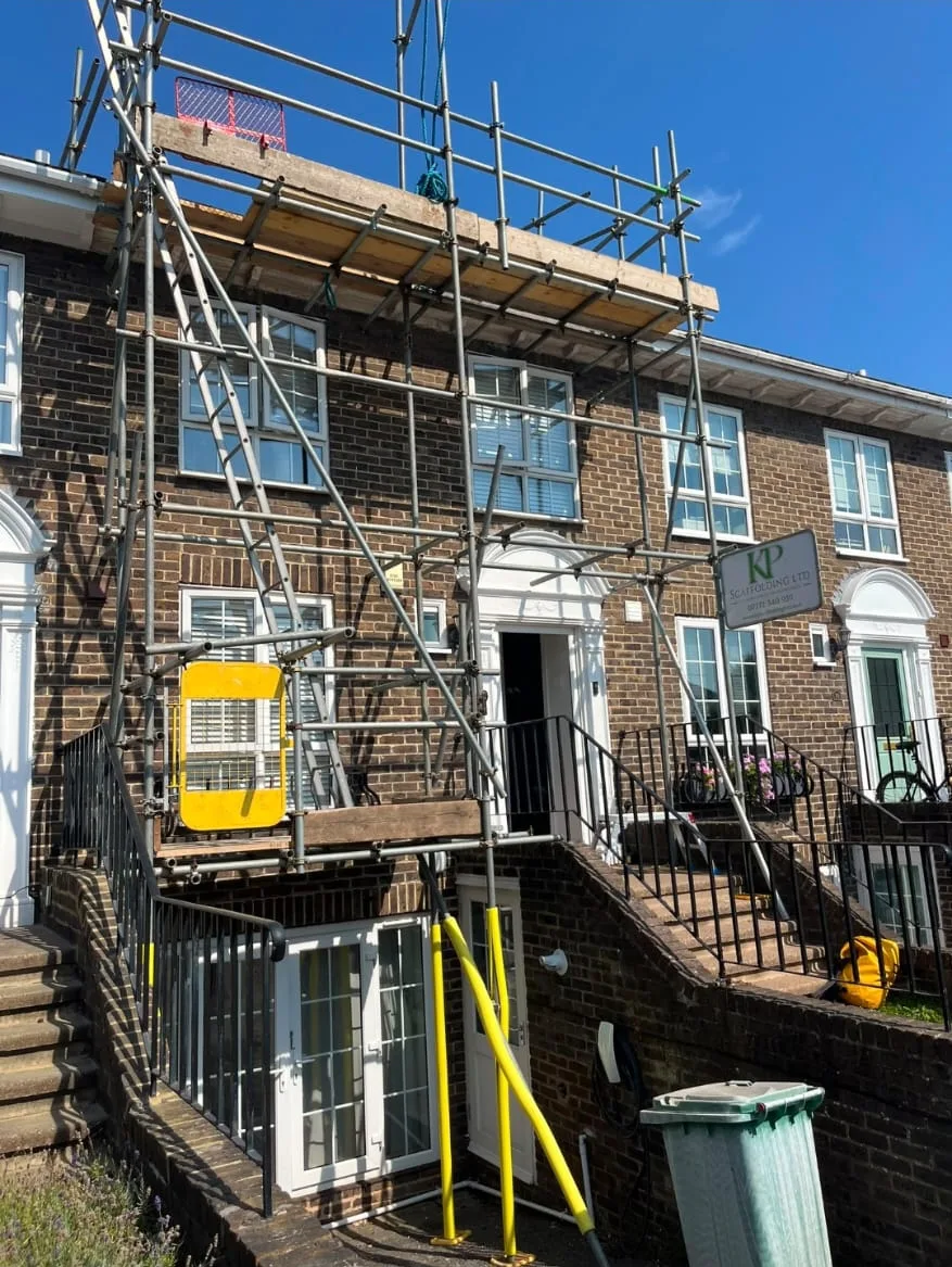 Domestic scaffolding outside a terraced house with a KP Scaffolding sign