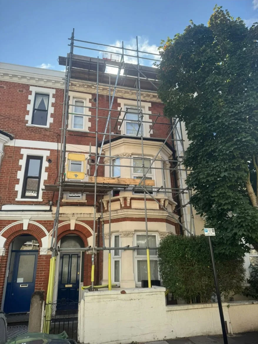 Scaffolding around the bay windows and roof of a residential property