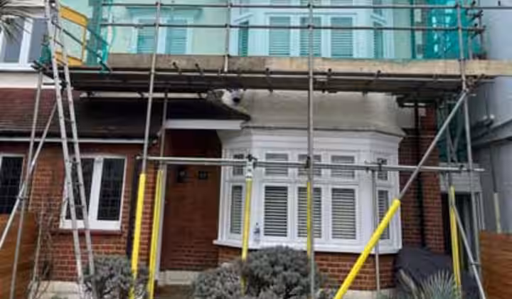 Scaffolding around a house with green safety netting